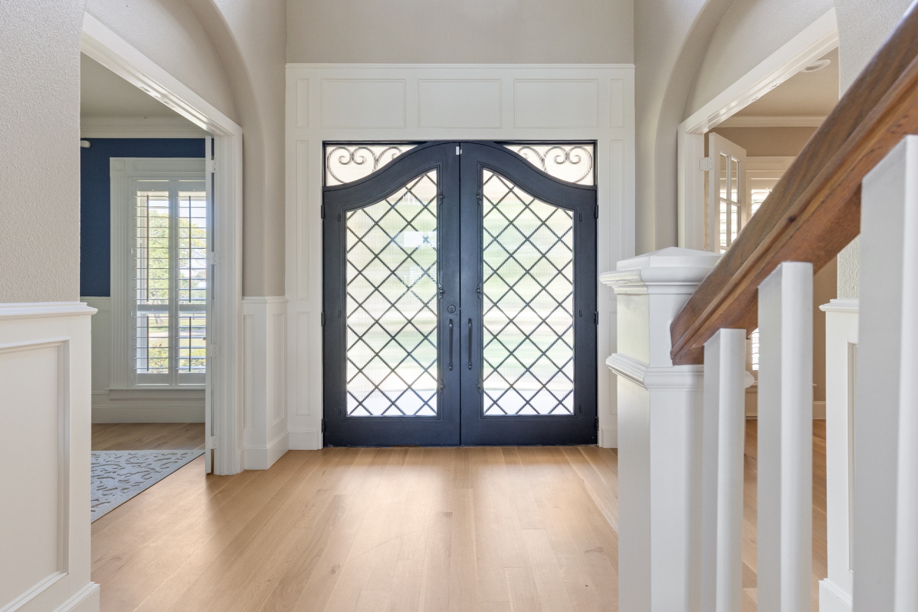 Two-story foyer with wrought iron double doors