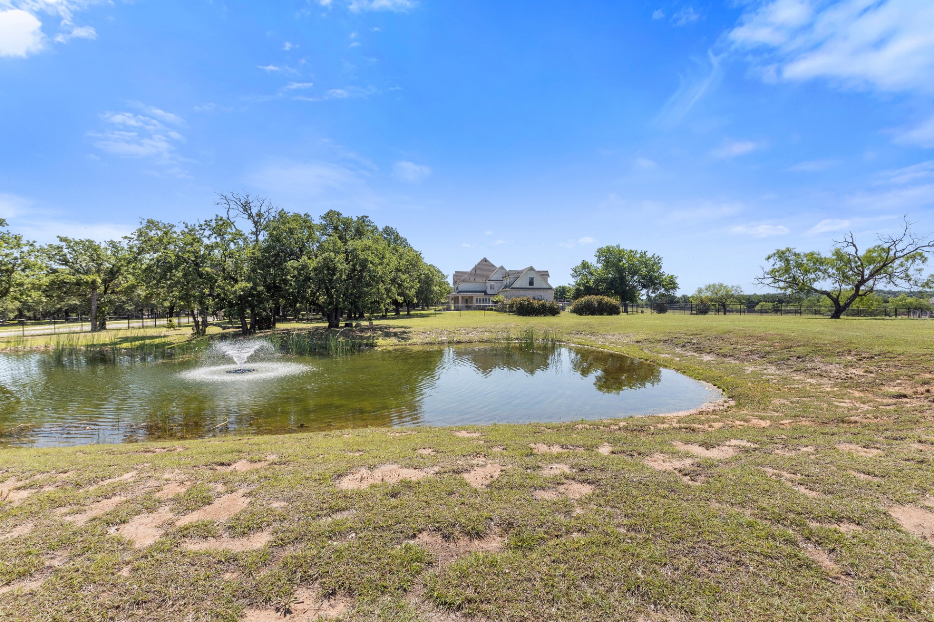 Pond with fountain and estate in background