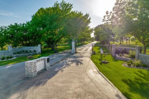 Gated stone-column entrance to Cattlebaron Parc II